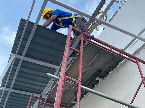 Construction workers performing architectural work on a building exterior, highlighting KBuild's design and planning expertise.